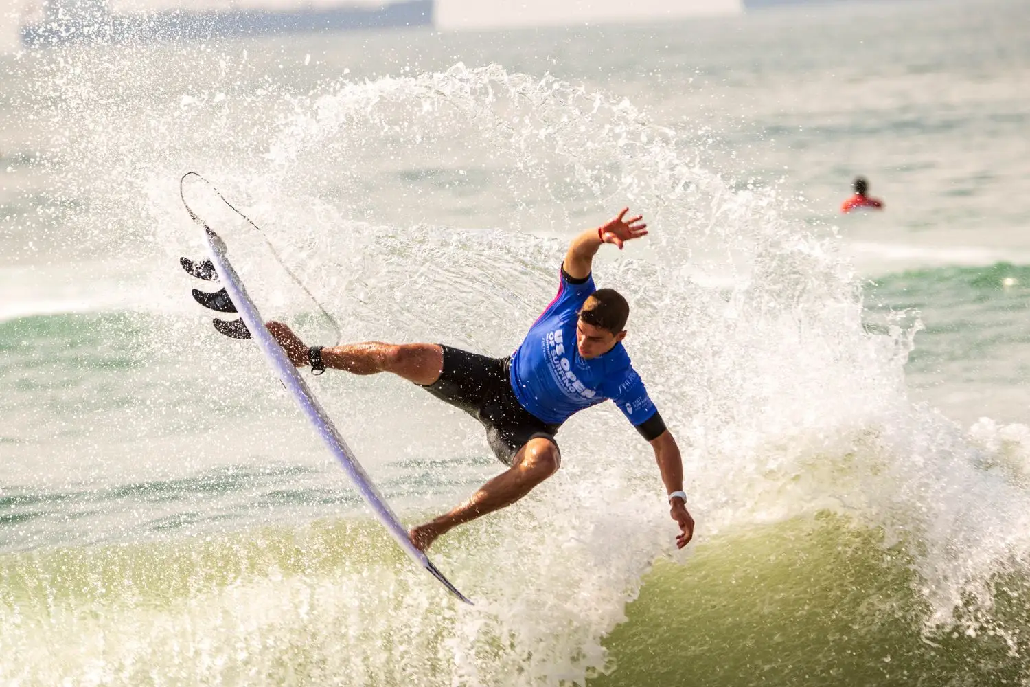 Surfer completing an aerial turn on a wave