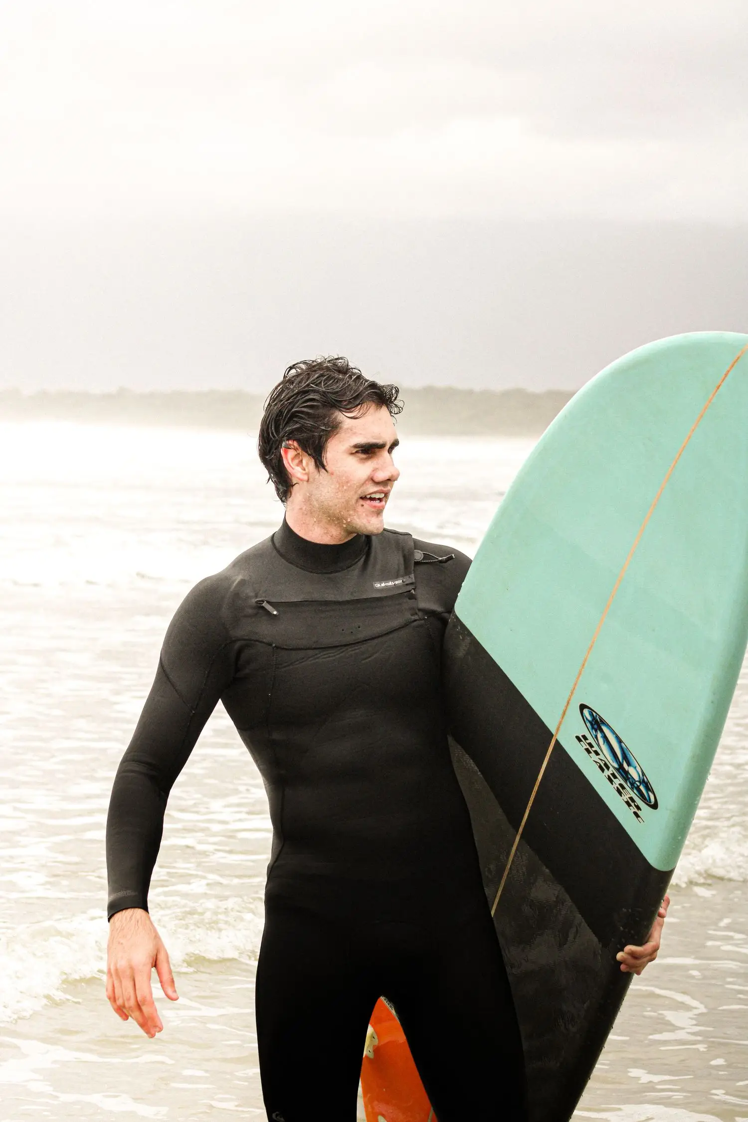Surfer carrying a board after a training session