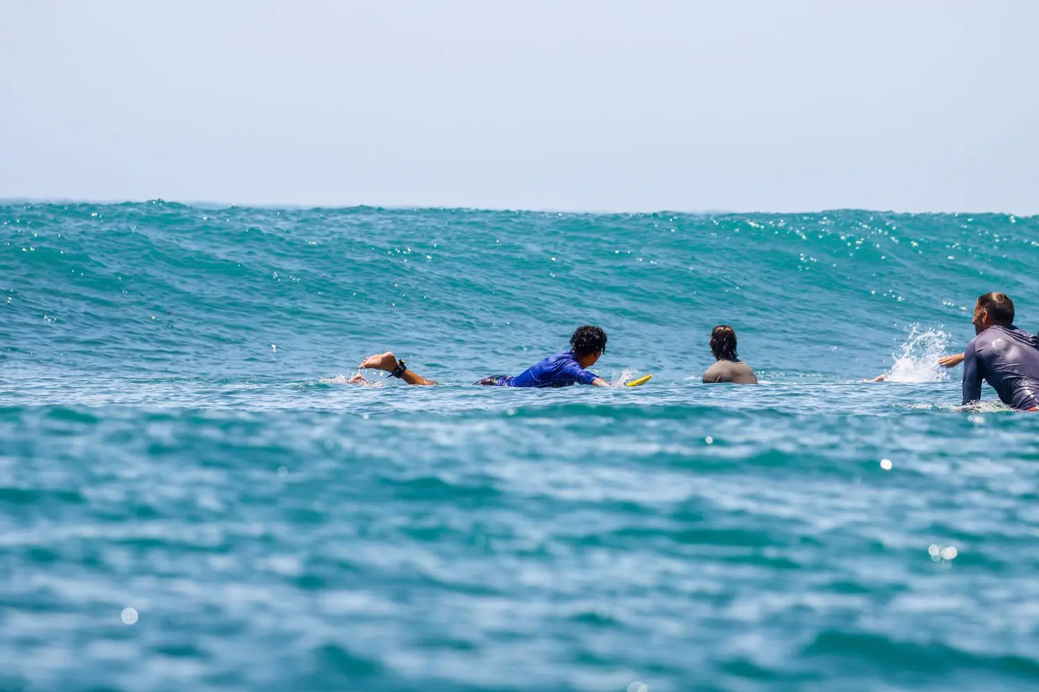 Surfers paddling together in open water