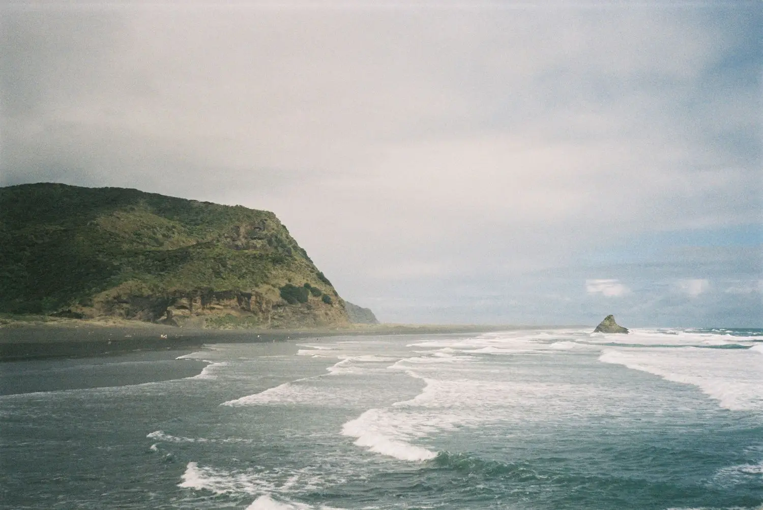 Coastal point and breaking waves under an overcast sky