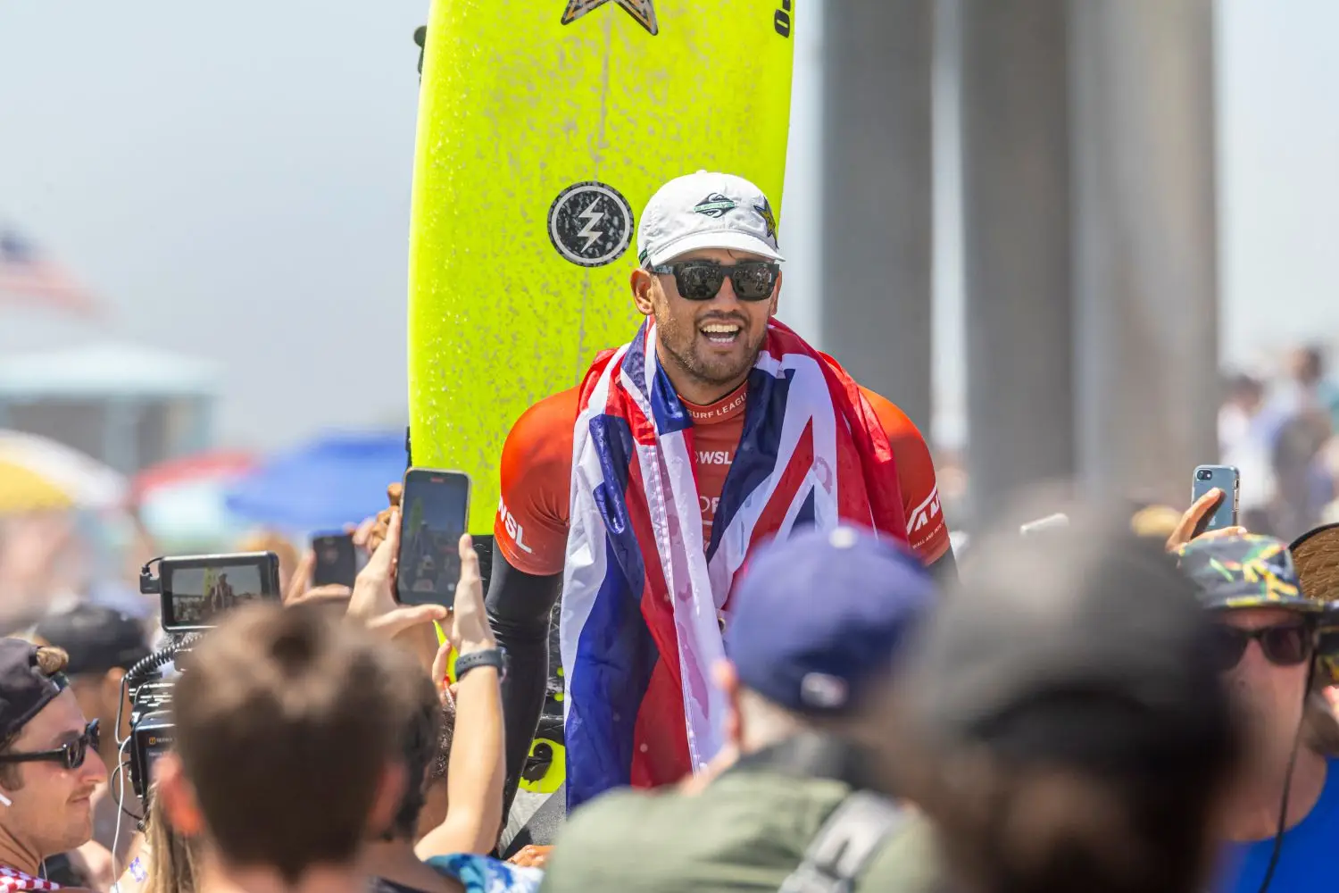 Competition surfer and board near a crowd at a surf event
