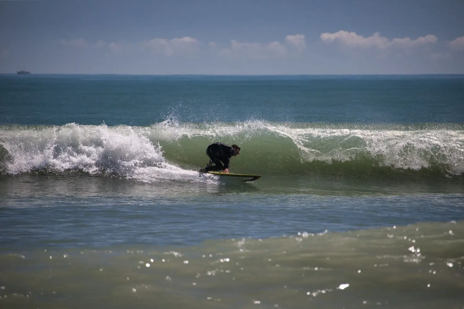 Surfer travelling through a clean breaking wave