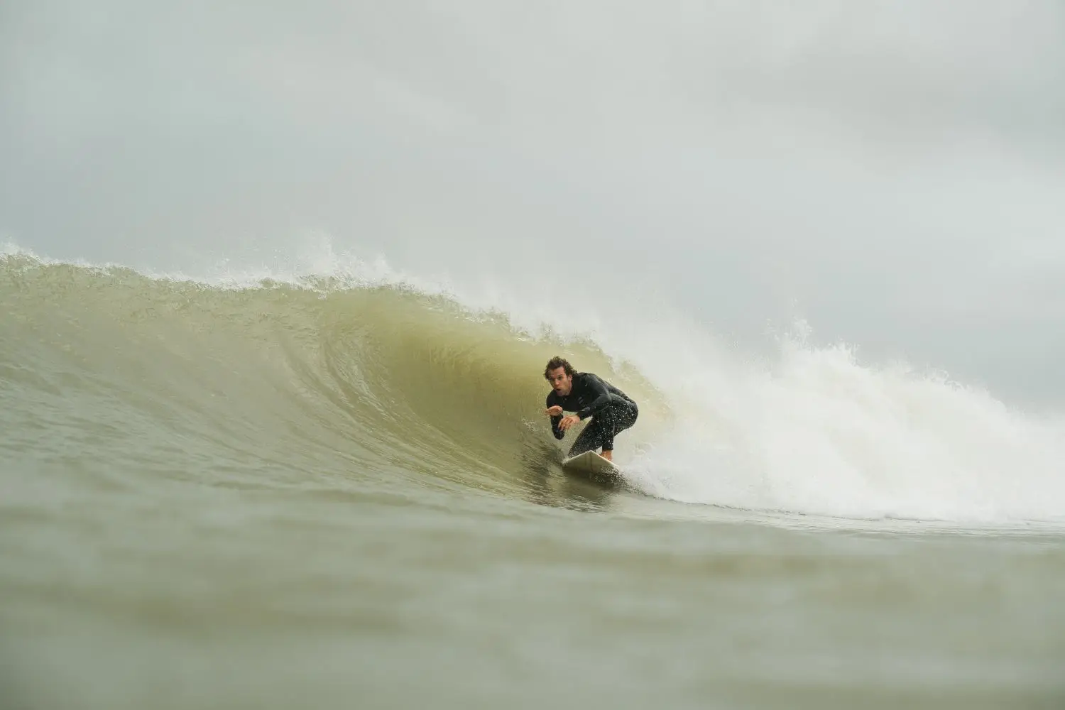 Surfer riding inside a clean breaking wave